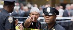 A witness talks with police at a Manhattan crime scene, Wednesday, May 13, 2015, in New York, after a man apparently wielding a hammer was shot and wounded by police. The shooting took place shortly after 10 a.m., blocks from Madison Square Garden and Penn Station. (AP Photo/Mark Lennihan)